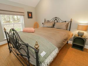 a bedroom with a large bed with a large window at Cloneytrace Mines in Ballymena