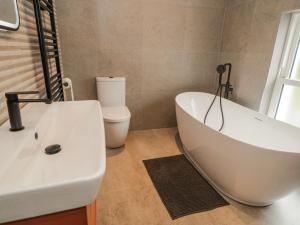a bathroom with a white tub and a toilet at Cloneytrace Mines in Ballymena +35 photos