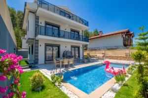 a villa with a swimming pool and a house at Villa Huzur in Fethiye