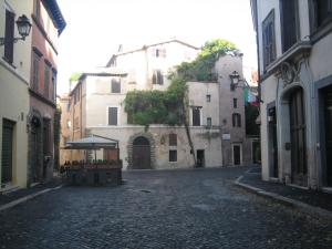 an empty street in an alley with buildings at Polacchi 42 Apartment in Rome