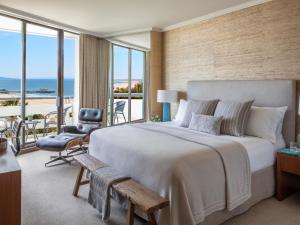 a bedroom with a large bed and a balcony at Fairmont Miramar Hotel & Bungalows in Los Angeles
