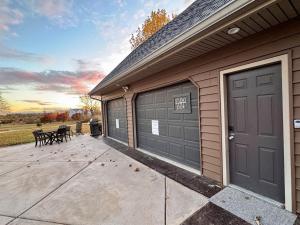 a garage with two garage doors and a sign on it at Set on peaceful 5 acres, 5 min from town, Private Building, Level 2 EV Charger in Bloomington