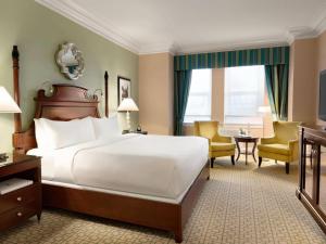 a hotel room with a bed and a desk and chairs at Fairmont Chateau Laurier in Ottawa +178 photos