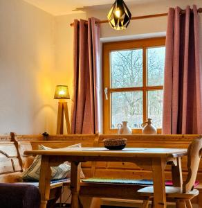 a living room with a table and a window at Der Blankhof "Back to Roots" in Bad Endorf