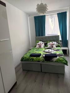 a bedroom with a bed with a green comforter at Habibi Plac Ratuszowy in Jelenia Góra