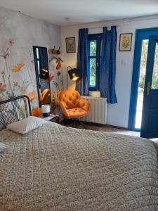 a bedroom with a bed and a chair and windows at Kékfestő Vendégház in Bükkszentkereszt