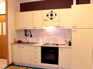 a kitchen with white cabinets and a stove top oven at La casa del Darda 3 in Ancona