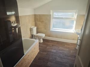a bathroom with a tub and a toilet and a sink at St Peters Avenue in Cleethorpes