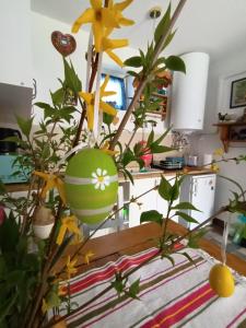 a vase filled with yellow flowers on a table at Kékfestő Vendégház in Bükkszentkereszt