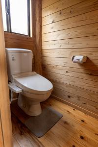 ein Badezimmer mit einer Toilette in einer Holzwand in der Unterkunft Amakusa LogHouse UmiOTO 海音 in Amakusa + 23 Fotos