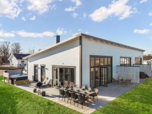 a white house with a patio and a lawn at Nybyggt hus med 3 sovrum, jacuzzi och närhet till strand in Bergkvara