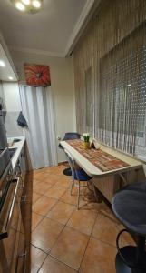 a kitchen with a table and chairs in a room at Lotti Apartman in Békéscsaba
