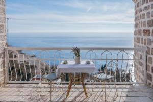 a table and chairs on a balcony with the ocean at Apartments Pietra Mare in Petrovac na Moru