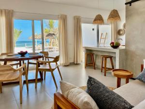 a living room with a table and chairs and the ocean at Beachfront Apartments with Private Pool in Kiwengwa