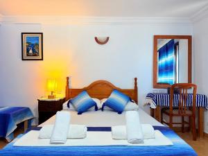a bedroom with a bed with blue and white pillows at Casa Olea Vista in Chefchaouen