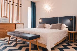 a bedroom with a large bed with a black headboard at Tuscany Hotel Alle Dune in Marina di Castagneto Carducci +100 photos