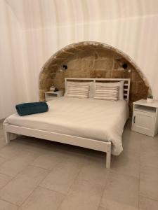 a bedroom with a large bed with a stone wall at Casa Angel in Mesagne