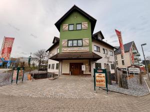 a large green and white building with signs in front of it at Hotel Kraus - Zentral in Bielefeld-Heepen, Gratis Parken, 24h Self Check-in in Bielefeld