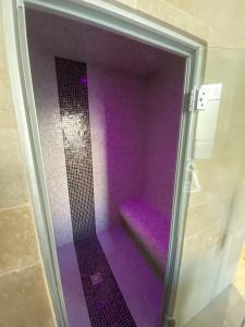 a purple shower with a purple bench in a room at Sweety Room in Chamalières