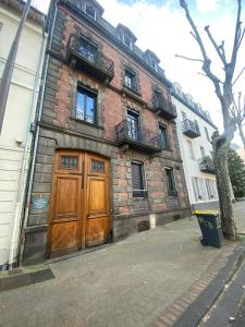 a brick building with two wooden doors on a street at Sweety Room in Chamalières