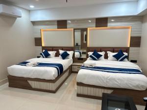 a bedroom with two beds with blue and white pillows at Hotel Manjit Banquet in Fālākāta