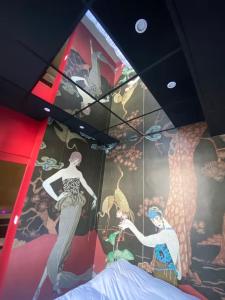 a room with a mural of women on the wall at Sweety Room in Chamalières