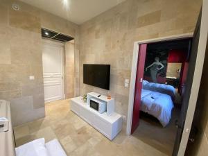 a living room with a television and a bed at Sweety Room in Chamalières