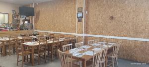 a restaurant with wooden tables and chairs in a room at Pension Casa Curro in Palas de Rei