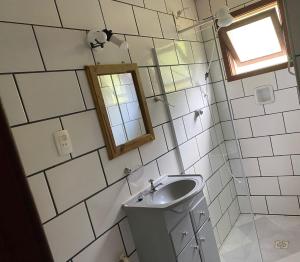 a small bathroom with a sink and a mirror at Pousada Cantinho da Montanha 2 in Visconde De Maua +54 photos