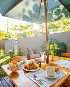 a wooden table with breakfast foods and drinks on it at Pousada Do Capitão in Florianópolis