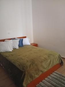 a bedroom with a large bed with pillows at T&S Guest House in Praia