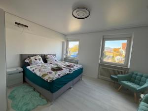 ein Schlafzimmer mit einem Bett, einem Stuhl und einem Fenster in der Unterkunft Traumwelt in Flemlingen