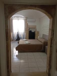 a bedroom with a bed and a window in a room at Da Adriana NETUM in Noto