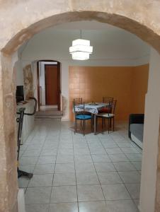 a living room with a table and chairs in a room at Da Adriana NETUM in Noto