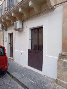 a door on the side of a white building at Da Adriana NETUM in Noto