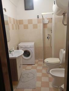 a bathroom with a toilet sink and a washing machine at Da Adriana NETUM in Noto