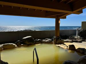 a pool of water with rocks and the ocean at Rishiri Antique Inn in Rishiri