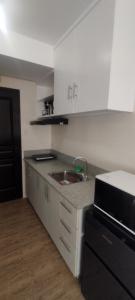 a kitchen with a sink and a microwave at Stanford Suites 1 in Silang