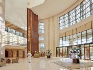 a man walks through the lobby of a building at Fairmont Ajman in Ajman 