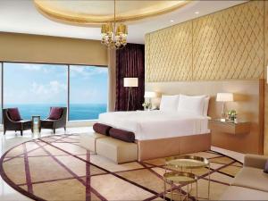 a bedroom with a large bed and a large window at Fairmont Ajman in Ajman  +164 photos