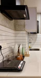 a kitchen counter with a remote control on a counter top at The Warmwood Studio in Dehradun