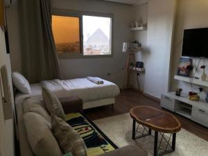 a living room with a couch and a bed and a window at Rafifi pyramids inn view in Cairo