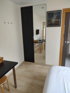 a bedroom with a mirror and a table and a bed at Le Pic-Vert in Rang-du-Fliers