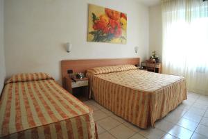 a hotel room with two beds and a window at Hotel Riviera Blu in Tirrenia
