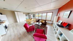 a living room with red chairs and a table at Brenna - Ocean View Apartment in Hellissandur