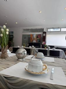 a table with plates and dishes on top of it at HOTEL LE FLOREAL in Le Soler