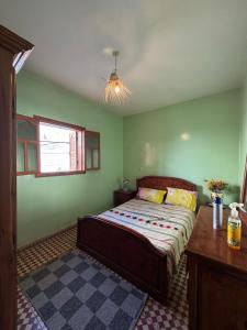a bedroom with a bed in a green room at Love Wave House in Agadir