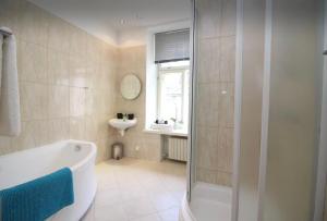 a bathroom with a shower and a tub and a sink at Tallinn City Apartments - Old Town in Tallinn +97 photos