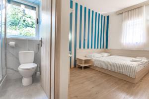a bedroom with a bed and a window and a toilet at Maestral Residence in Portorož +80 photos