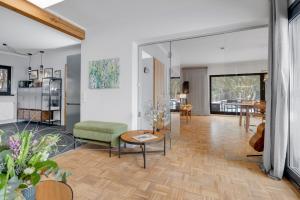 a living room with a green chair and a table at Stilvoller Bauhaus Bungalow mit Sauna in Lüneburger Heide für 8 Gäste in Wohlendorf